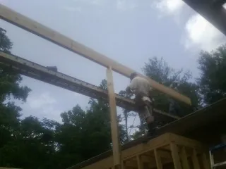 Carpenter setting a ridge beam over a new addition frame — Ice Dam Removal by Roofing Brothers in White Pine