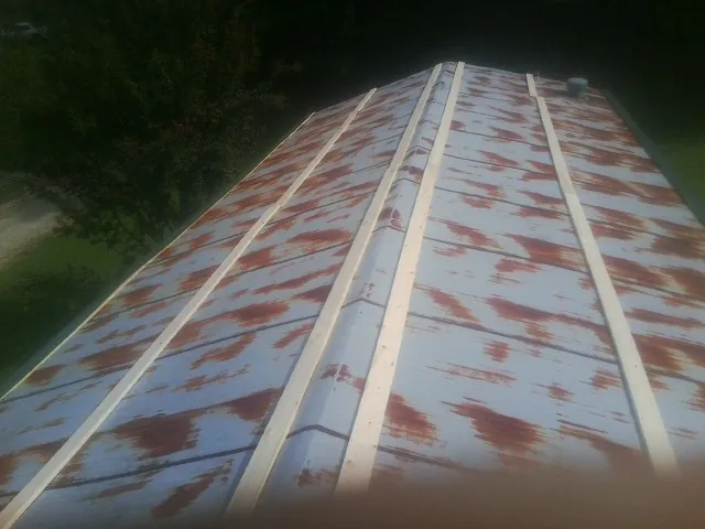 Rusted metal roof panels with new wood purlins before replacement — Storm Damage Roof Repair in White Pine by Roofing Brothers