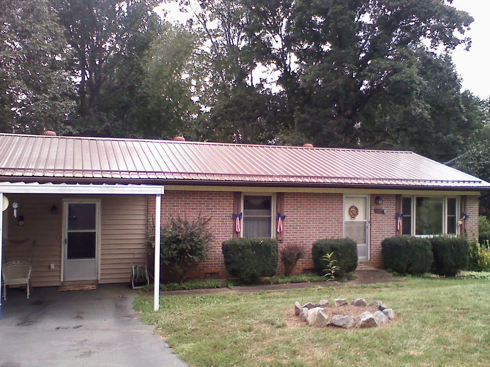 Bronze metal roof and carport on a brick ranch home — Roof Repair work by our crew in White Pine